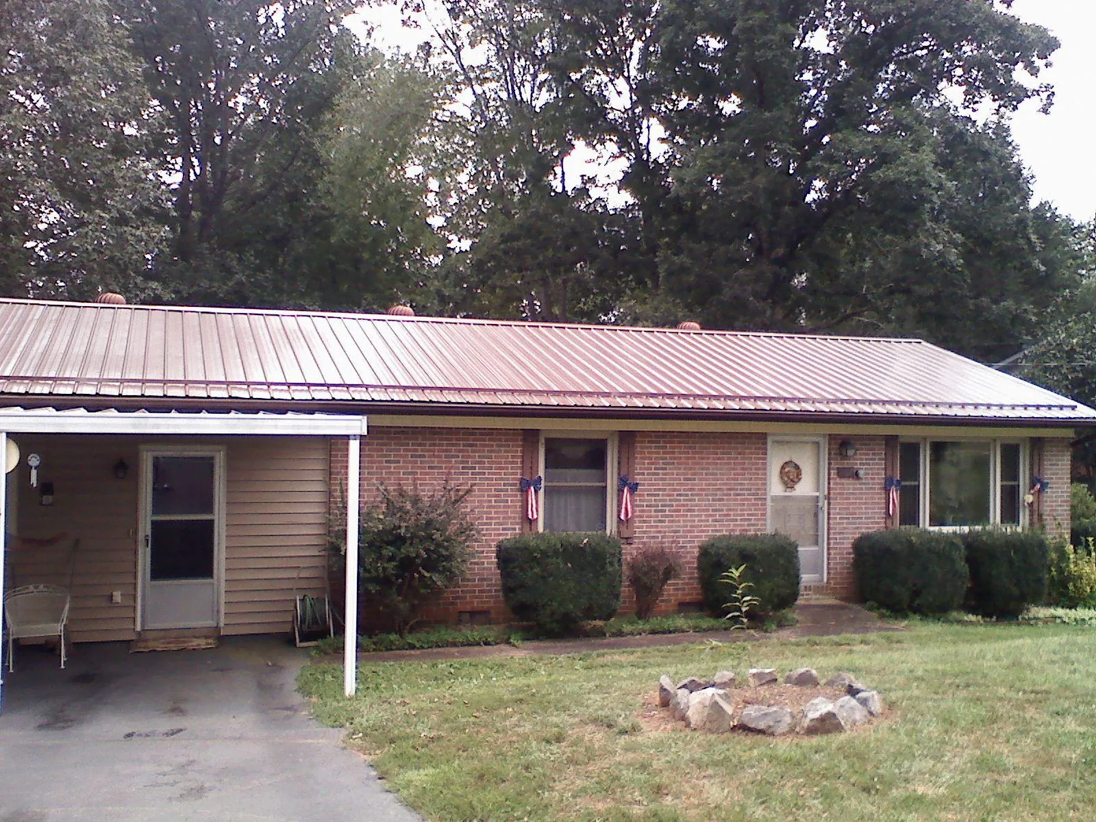 Bronze metal roof and carport on a brick ranch home — Roof Repair work by our crew in Horatio